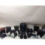 A selection of glass binoculars and field glasses, camera lens, and other items to include a