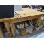 A pine kitchen table with rectangular top with shaped corners, on turned legs 78cm x 135cm x 89.