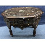 A late 19th/early 20th century Middle Eastern heavily carved occasional table having mother of pearl