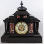 A late Victorian black slate mantle clock of architectural form and striking on a gong Location: