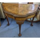 An early 20th century walnut fold over card table having cabriole legs with ball and claw feet, 77cm