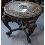 A late 19th/early 20th century Indian heavily carved circular topped occasional table, the four legs