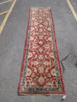 A Ziegler runner with a blue border and decorated with a repeating irregular design with three