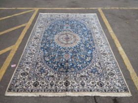 An Isfahan port silk rug with a floral cream border decorated with simplistic flowers and a large
