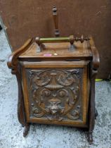 A late 19th century carved oak coal scuttle with carved ornament to the front, metal liner and