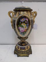 A 19th century porcelain and gilt metal vase and cover decorated with panels of flowers and