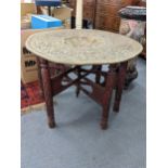 A Middle Eastern brass tray table on a folding base Location: