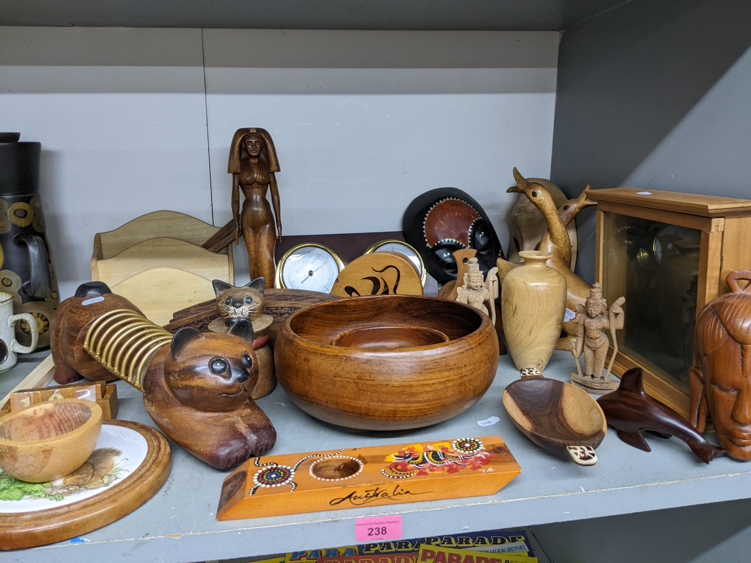 A collection of wooden items from around the world to include two Indian deities, a barometer/
