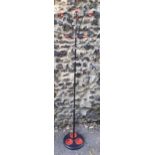 A retro hat stand with red accents to the coat hooks and base below Location: RWB