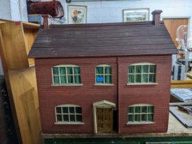 A Victorian style two storey wooden doll house with brick facade partially furnished interior