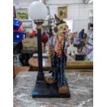A large painted fibreglass table lamp fashioned as a clown next to a street lamp Location: