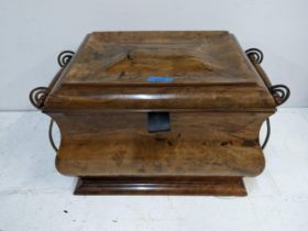 A 20th century walnut casket with a shaped top and sides with metal and wooden scrolled handles