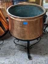 An early to mid 20th century copper log basket with wrought iron loop handles and strapwork,