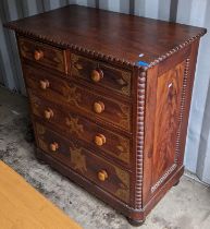 A Victorian chest of two short and three long drawers having pokerwork drawers with bun shaped