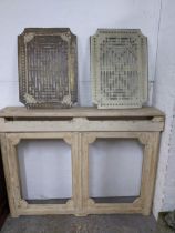 A painted wooden radiator surround, with painted concrete mantel, and twin brass grills with cast