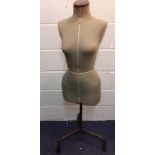 A mid 20th Century Singer green fabric dressmakers mannequin on adjustable wrought iron tripod