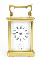 A French brass and bevelled glass cased alarm clock, with white enamel face with Roman numerals,