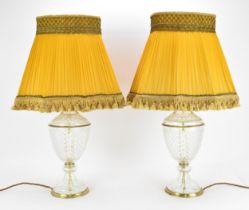 A pair of contemporary glass table lamps with gilt metal fittings, together with yellow fabric