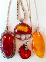Four modern amber pendants on silver tone mounts and silver tone chains (no hallmarks) to include