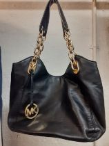 Michael Kors-A modern black soft leather shoulder bag having gold tone chain partial straps and a
