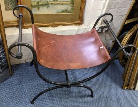 A wrought iron and brown leather stool having a scrolled frame, 61.5cm h x 77.5cm w Location: