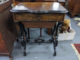 A late 19th century French walnut and ebonized work table with serpentine legs and carved stretchers