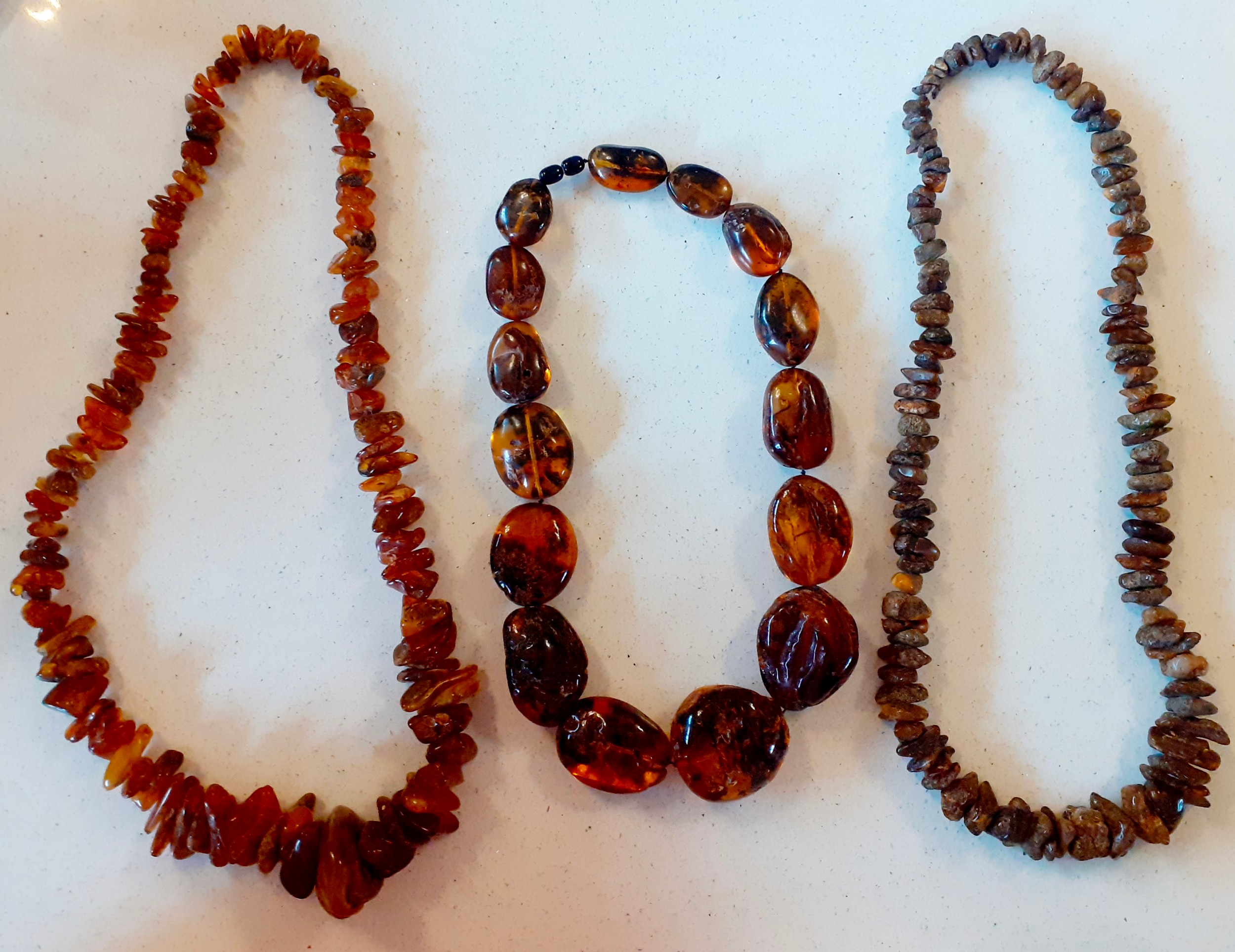 A vintage amber necklace having 15 beads of various sizes and shapes together with 2 vintage rough-