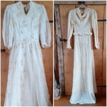 Two 1930's cream wedding dresses, one dress having an overlay of button mesh with cream leaf