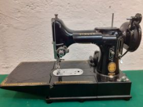A Singer Featherweight 222K electric sewing machine with accessories and black travel case