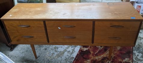A mid-century teak low dressing table with six short drawers on tapering legs 67.5cm x 147cm x