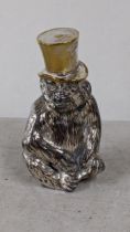 A German cast metal table light modelled as a seated monkey with a top hat, marked Wurttemberg to