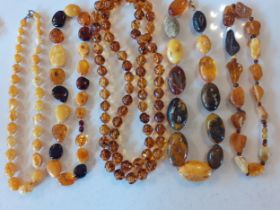 Five late 20th Century amber necklaces to include egg yolk amber beads and a yellow Baltic amber