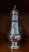 An early 20th century silver sugar caster with a pierced design and domed foot, stamped with a