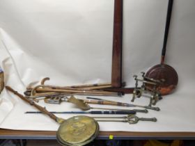 A mixed lot to include brass fire irons and copper warming pans, walking sticks, a brass effect