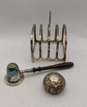 A silver toast rack hallmarked Birmingham 1913, together with a floral embossed trinket box and a