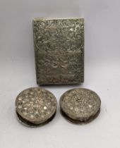 A white metal floral embossed compact case A/F, together with white metal possibly Indian ornate