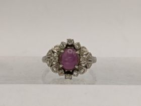 A platinum ring stamped 850 set with a central purple stone and diamonds, total weight 4.4g