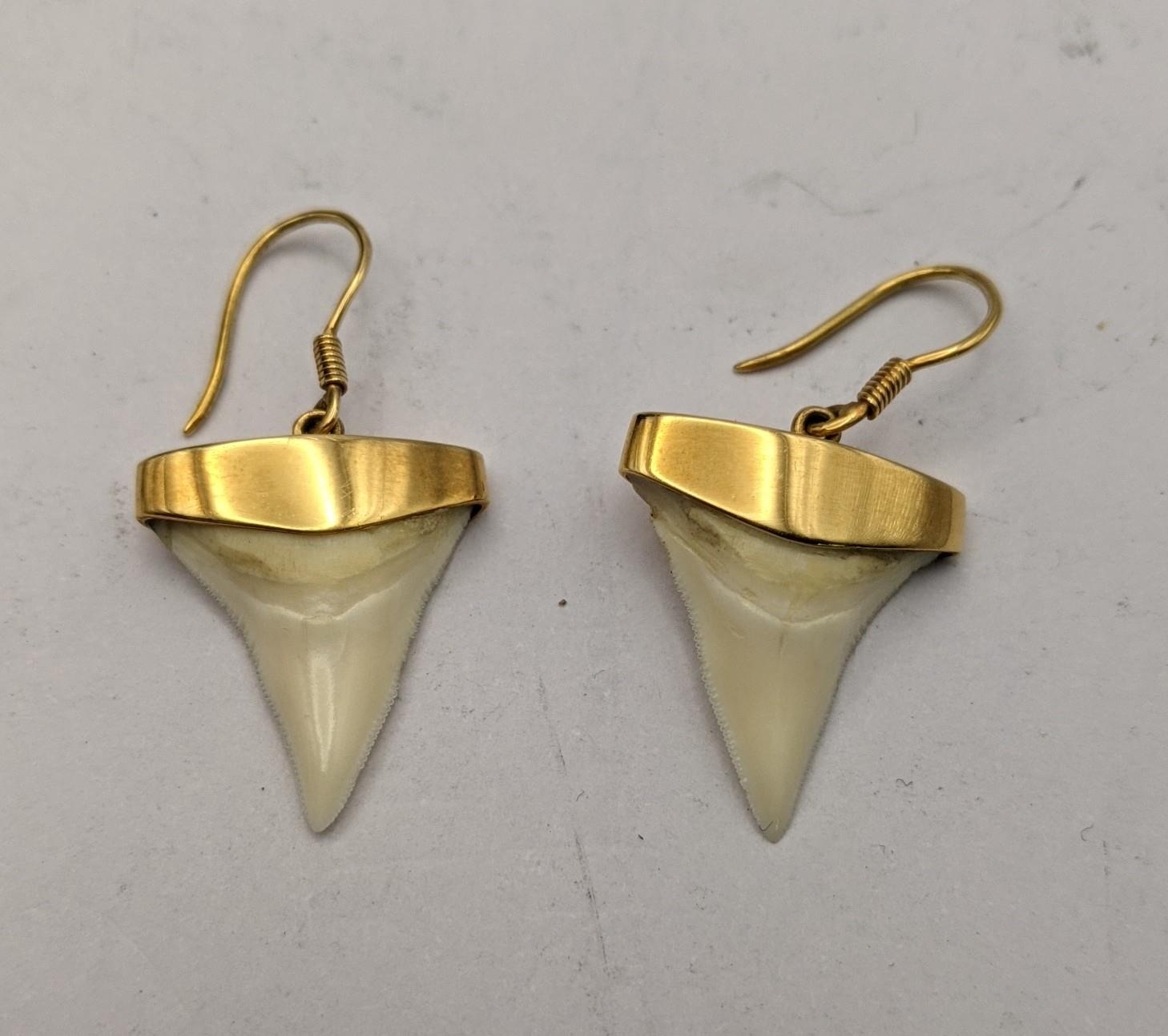 A pair of 18ct gold earrings stamped 750 set with fish teeth Location: