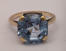 A yellow metal ring having a faceted cut blue topaz in a claw setting, 4.8g Location: