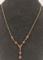 A 9ct gold ruby drop pendant necklace having seven rubies and on a chain link necklace 4.4g