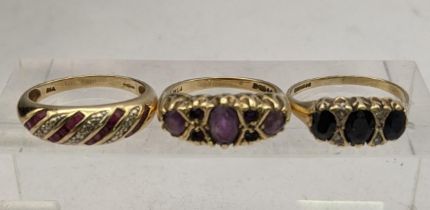 Three 9ct gold rings to include a diamond and ruby bomb ring, a ring set with amethysts and one