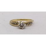 An 18ct gold ring set with a diamond approx 0.25ct and four diamonds to each shoulder Location:
