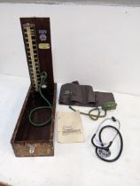 A mid 20th century Accoson Sphygmomanometer in a wooden case and a stethoscope Location: G
