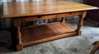 A modern solid oak two tier coffee table having two drawers and on turned legs, 47cm h x 120cm w