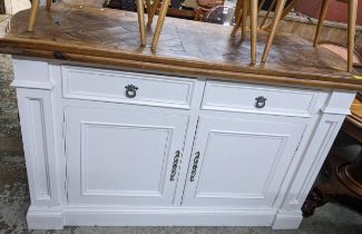 A 20th century kitchen island with a pine top over a white painted pine base with two doors and