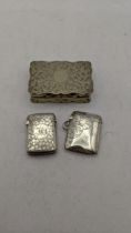 Two siler vesta cases having a floral engraved pattern and initials, 30.1g, together with a silver