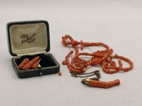 Coral jewellery to include three teardrop shaped pendants, along with coral beads, and a carved Momo