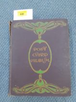 An Art Nouveau postcard album and contents to include 1915 and later examples, some franked with