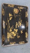 A 19th century Japanese black lacquered tray having gilt highlights and decorated with birds with