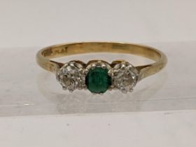 An 18ct platinum ring set with two diamonds and a central emerald size P, 2.9g Location: